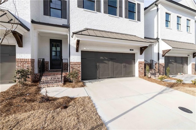816 Dodd Trl S Unit 172, Buford, GA 30518 - view of front facade featuring brick siding, a garage, a standing seam roof, and concrete driveway