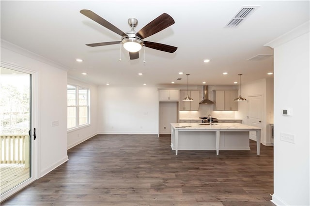 816 Dodd Trl S Unit 172, Buford, GA 30518 - kitchen featuring wall chimney range hood, a kitchen island with sink, a kitchen breakfast bar, baseboards, and decorative light fixtures