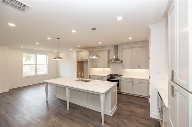 816 Dodd Trl S Unit 172, Buford, GA 30518 - kitchen featuring stainless steel gas range oven, wall chimney exhaust hood, backsplash, a sink, and a center island with sink