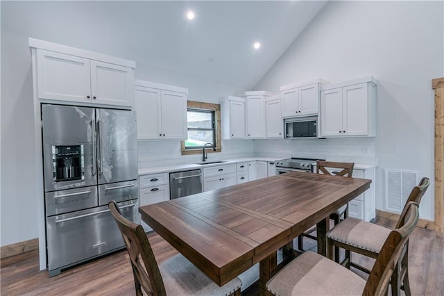 kitchen featuring stainless steel appliances, white cabinets, and tasteful backsplash