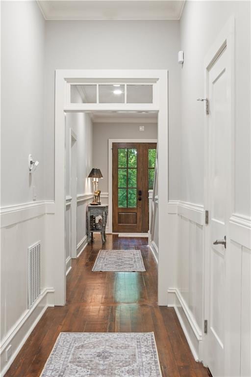 doorway to outside featuring visible vents, wood-type flooring, and ornamental molding