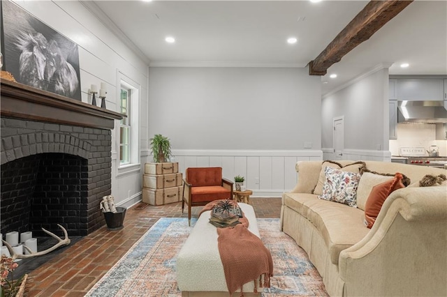 living room featuring beam ceiling, a fireplace, and ornamental molding