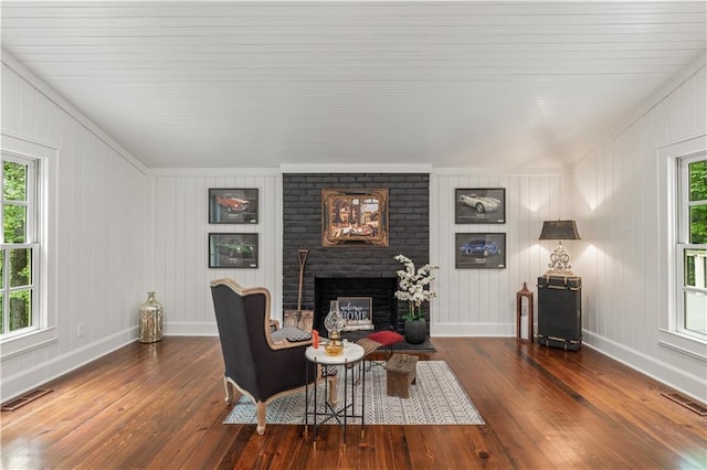 living room with visible vents, a fireplace, and hardwood / wood-style flooring