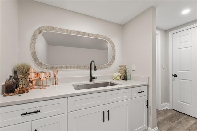 interior space with light wood-type flooring, white cabinets, and sink