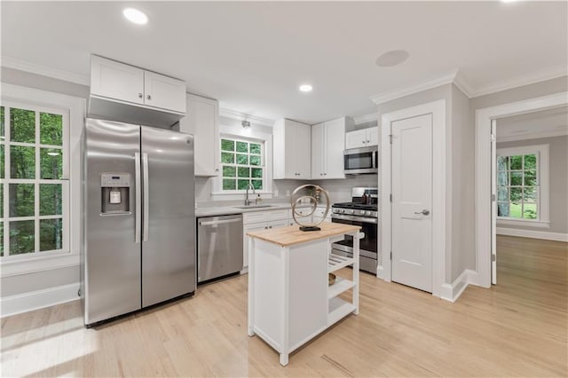 kitchen featuring wooden counters, sink, white cabinetry, light wood-type flooring, and appliances with stainless steel finishes