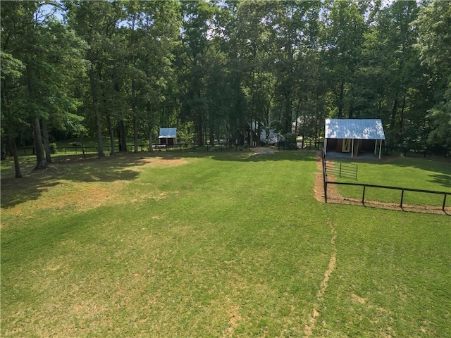 view of yard featuring an outbuilding, an outdoor structure, and fence