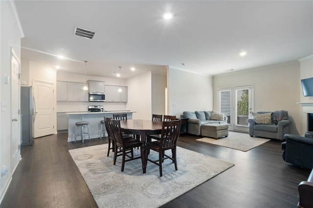 5755 Turnstone Trl, Flowery Branch, GA 30542 - dining area featuring dark wood-type flooring, recessed lighting, crown molding, and a fireplace