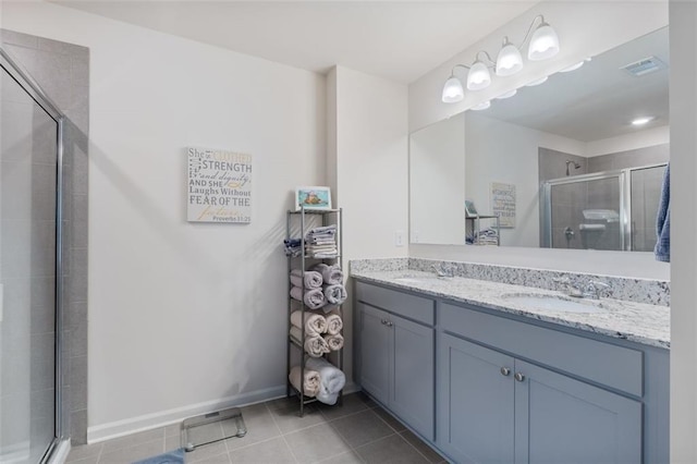 5755 Turnstone Trl, Flowery Branch, GA 30542 - bathroom featuring a shower stall, double vanity, tile patterned flooring, and baseboards