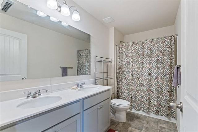 5755 Turnstone Trl, Flowery Branch, GA 30542 - full bath featuring double vanity, toilet, stone finish floors, and a shower with shower curtain