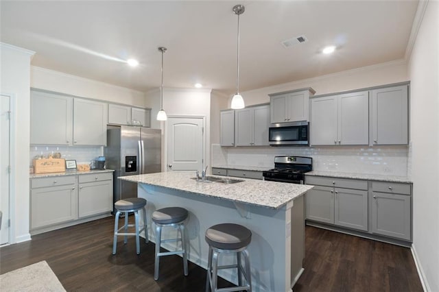 5755 Turnstone Trl, Flowery Branch, GA 30542 - kitchen with stainless steel appliances, gray cabinetry, a sink, backsplash, and dark wood-type flooring