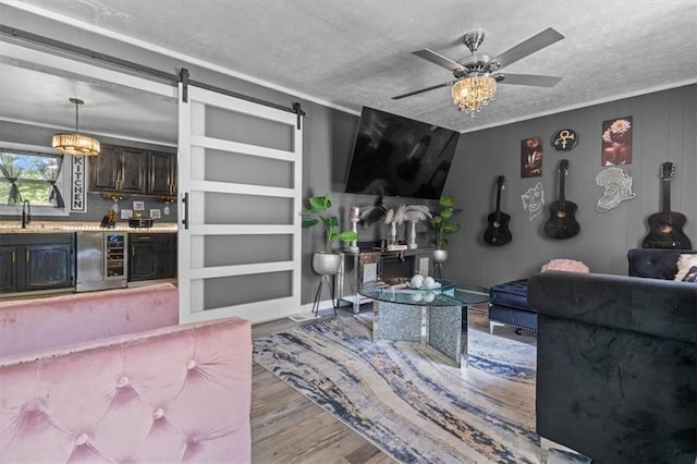 5143 3rd St, Morrow, GA 30260 - living area featuring wood finished floors, a textured ceiling, a barn door, ceiling fan, and wine cooler
