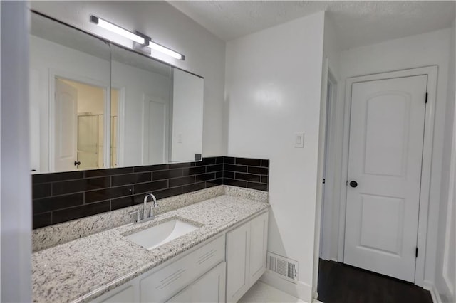 bathroom featuring vanity and tasteful backsplash