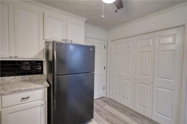 kitchen featuring freestanding refrigerator, light wood-style flooring, ornamental molding, white cabinetry, and ceiling fan