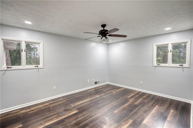 empty room featuring a ceiling fan, dark wood-style flooring, healthy amount of natural light, baseboards, and recessed lighting
