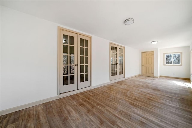 unfurnished room with french doors, wood finished floors, and baseboards