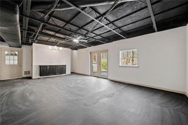 unfurnished living room featuring french doors, concrete floors, visible vents, and baseboards