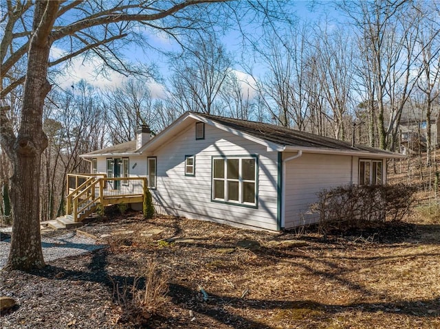 view of property exterior featuring a deck and a chimney