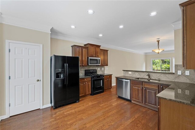 5159 Wellsley Bnd, Alpharetta, GA 30005 - kitchen featuring black appliances, a sink, ornamental molding, wood finished floors, and tasteful backsplash