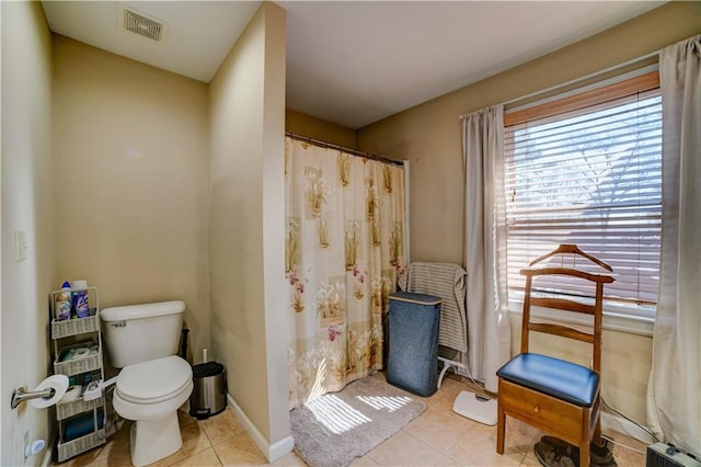 bathroom with a shower with curtain, tile patterned flooring, and toilet