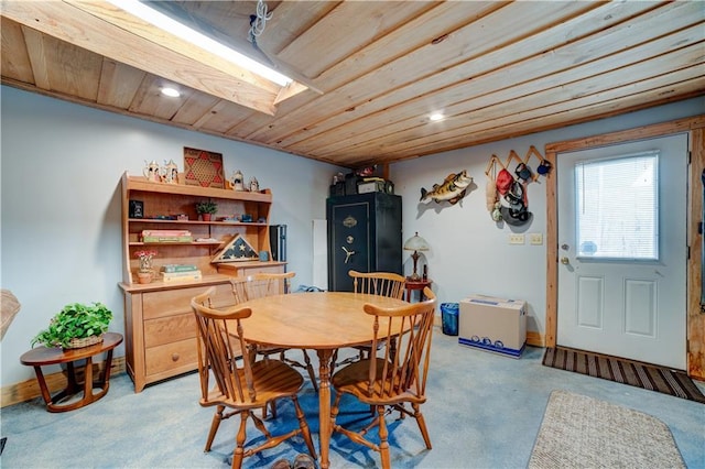 carpeted dining room featuring a skylight and wooden ceiling