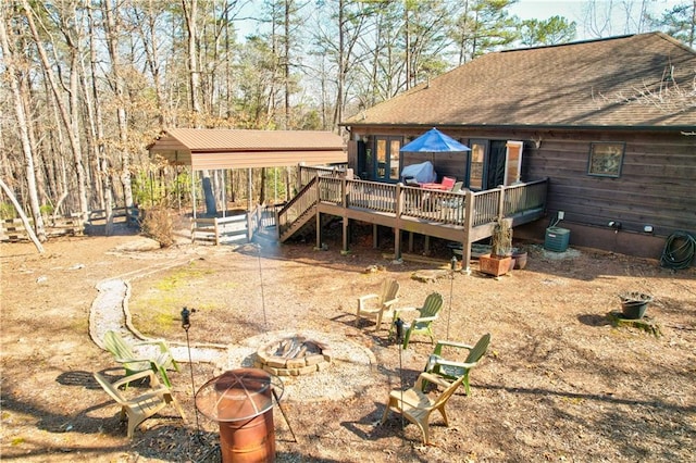 back of property with a fire pit and a deck