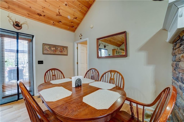 dining space with wood ceiling, high vaulted ceiling, and light hardwood / wood-style flooring