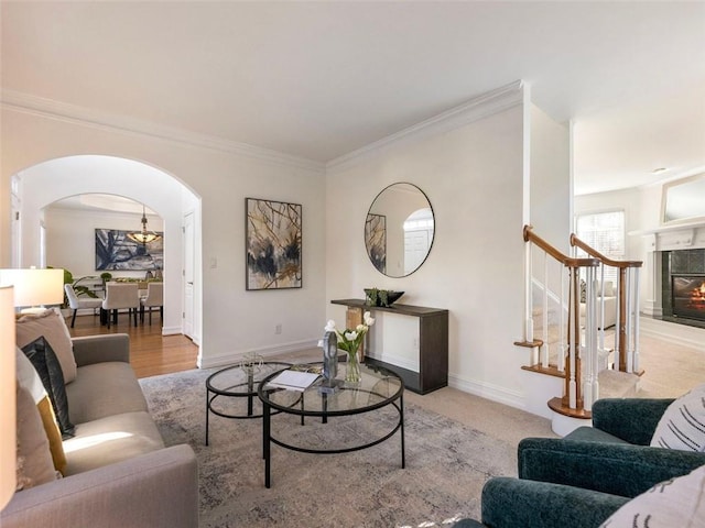 living room featuring light wood-type flooring, a premium fireplace, and crown molding