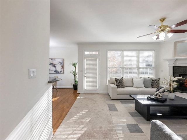 living room featuring ceiling fan, wood-type flooring, and a fireplace