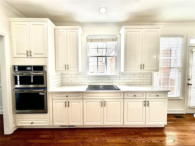 2750 Olde Towne Pkwy, Duluth, GA 30097 - kitchen with double oven, crown molding, light countertops, black electric stovetop, and white cabinetry