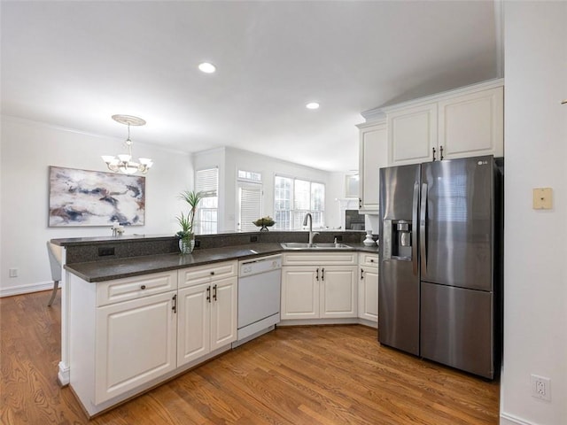 kitchen with white cabinets, dishwasher, sink, and stainless steel refrigerator with ice dispenser