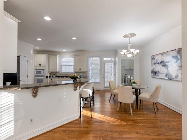 2750 Olde Towne Pkwy, Duluth, GA 30097 - kitchen with crown molding, white appliances, a kitchen breakfast bar, washer and clothes dryer, and a chandelier