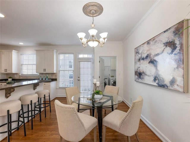 2750 Olde Towne Pkwy, Duluth, GA 30097 - dining space with a chandelier, crown molding, light wood-style flooring, washing machine and clothes dryer, and baseboards