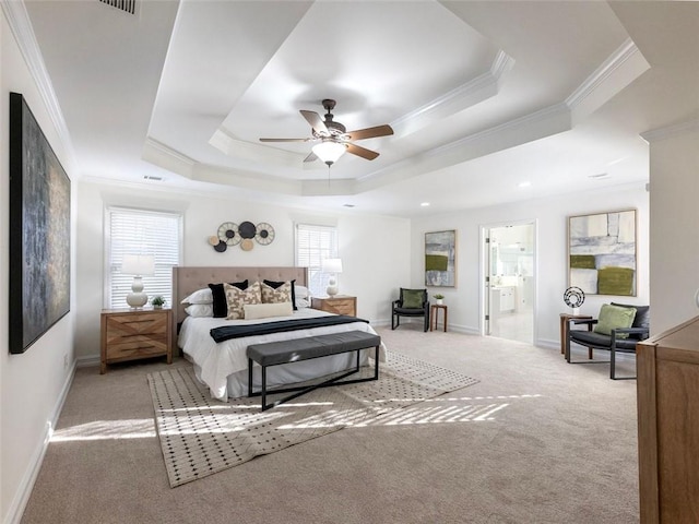 carpeted bedroom with ceiling fan, ensuite bath, crown molding, and a tray ceiling