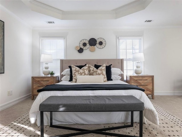 bedroom with crown molding, a raised ceiling, and light carpet