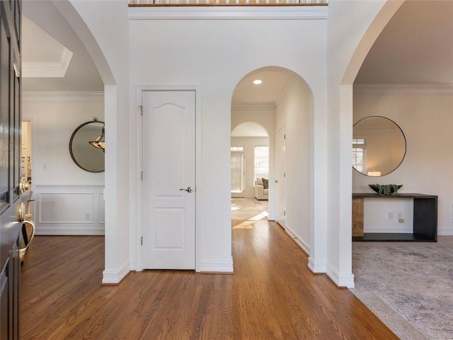 foyer with hardwood / wood-style flooring and crown molding