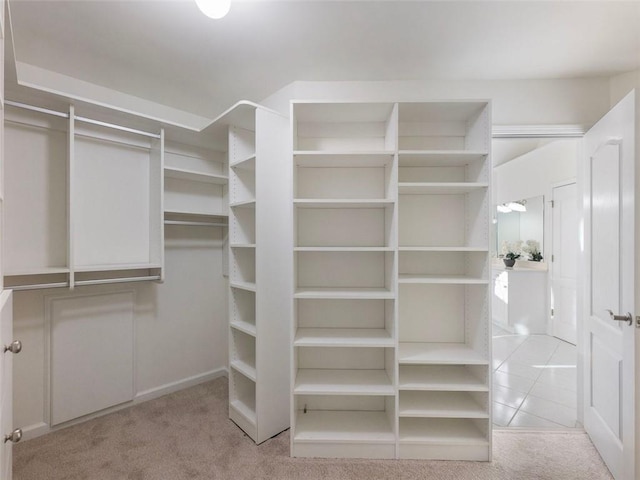 walk in closet featuring light colored carpet