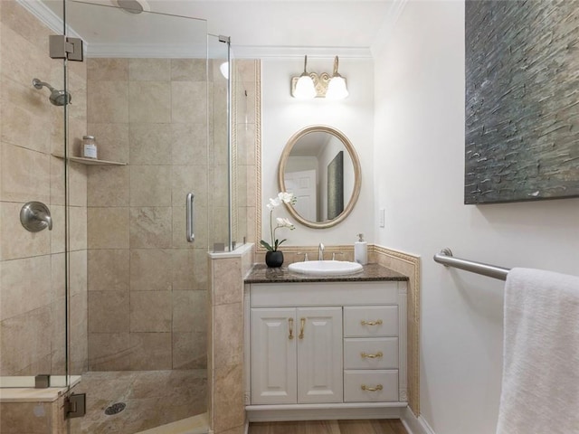 bathroom with vanity, a shower with door, and crown molding