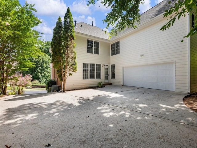 back of house with central AC and a garage