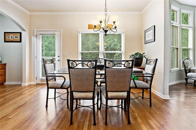 1898 Alcovy Shoals Blf SE, Lawrenceville, GA 30045 - dining area featuring arched walkways, a chandelier, wood finished floors, baseboards, and crown molding