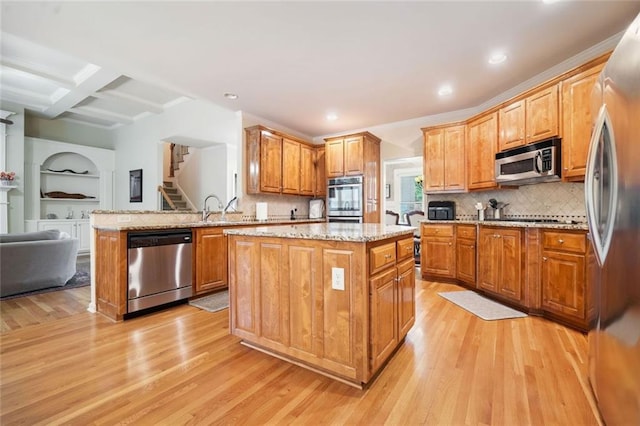 1898 Alcovy Shoals Blf SE, Lawrenceville, GA 30045 - kitchen with stainless steel appliances, light wood-style flooring, a center island, light stone counters, and beamed ceiling