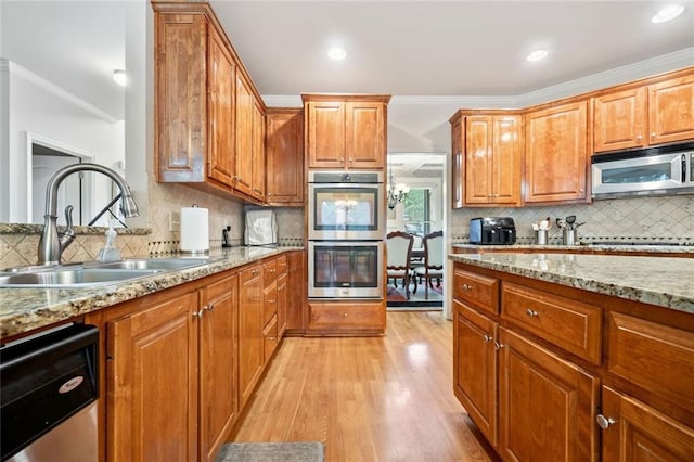 1898 Alcovy Shoals Blf SE, Lawrenceville, GA 30045 - kitchen featuring stainless steel appliances, a sink, tasteful backsplash, light wood-type flooring, and crown molding