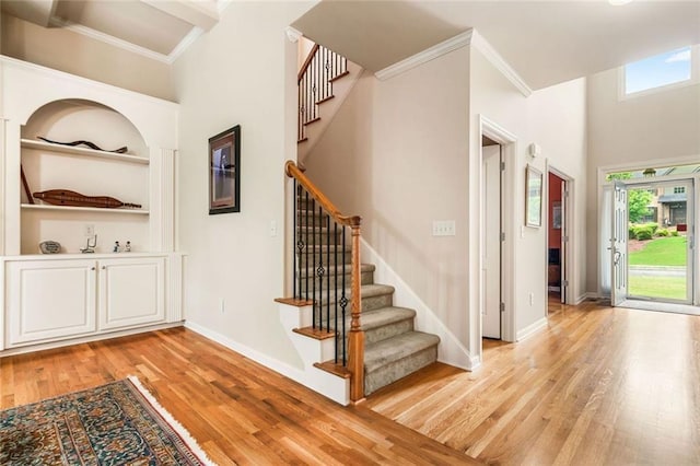 1898 Alcovy Shoals Blf SE, Lawrenceville, GA 30045 - staircase with wood finished floors, ornamental molding, a high ceiling, baseboards, and built in features