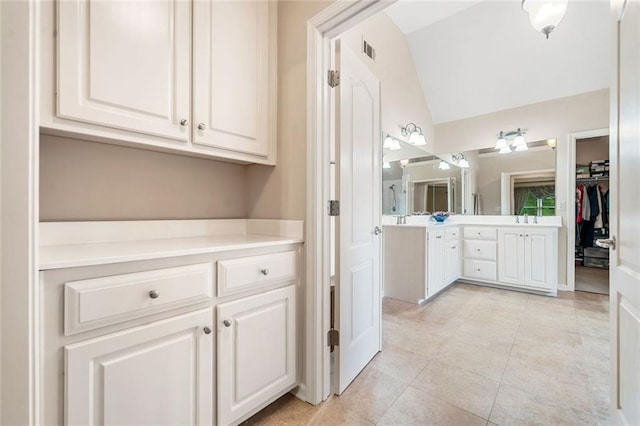 1898 Alcovy Shoals Blf SE, Lawrenceville, GA 30045 - full bathroom with vaulted ceiling, vanity, a walk in closet, and tile patterned flooring