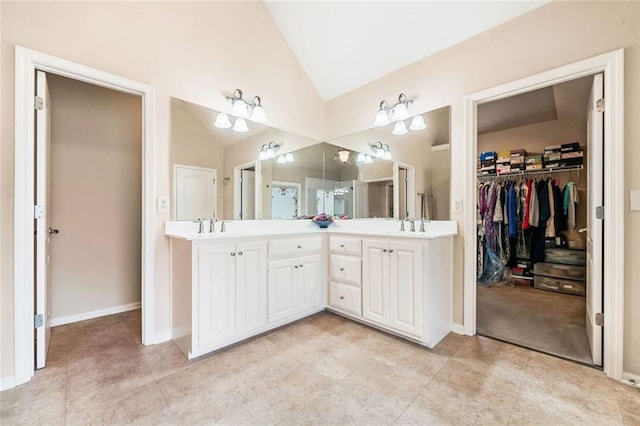 1898 Alcovy Shoals Blf SE, Lawrenceville, GA 30045 - bathroom featuring vaulted ceiling, double vanity, tile patterned flooring, a spacious closet, and baseboards
