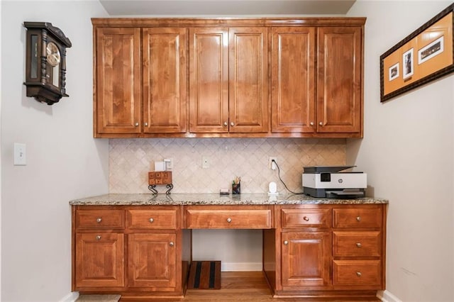 1898 Alcovy Shoals Blf SE, Lawrenceville, GA 30045 - kitchen with decorative backsplash, brown cabinets, and light stone countertops