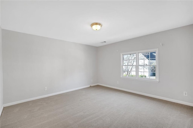 carpeted empty room featuring baseboards