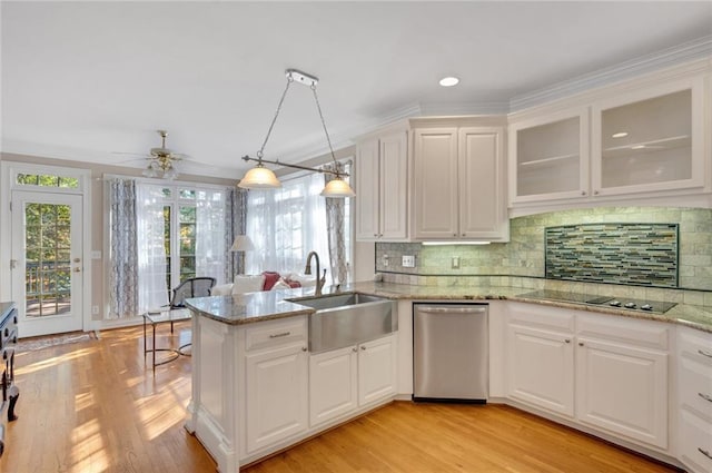 kitchen featuring dishwasher, a healthy amount of sunlight, white cabinetry, and a sink