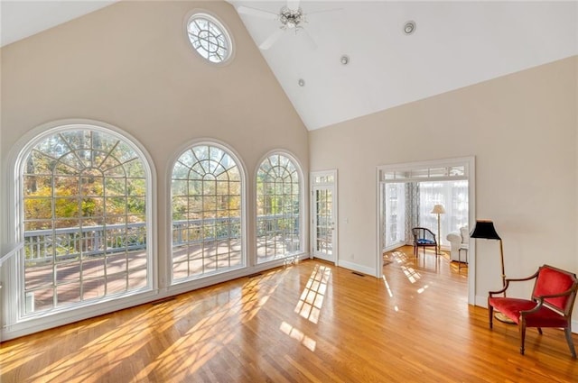 interior space featuring high vaulted ceiling, wood finished floors, baseboards, and ceiling fan