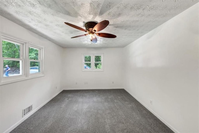 unfurnished room with carpet flooring, a ceiling fan, baseboards, and a textured ceiling