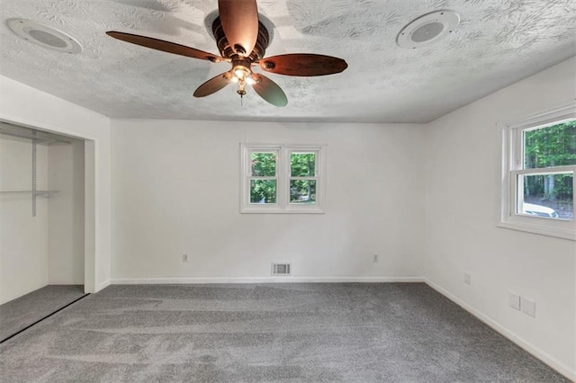 unfurnished bedroom featuring carpet, a textured ceiling, ceiling fan, and baseboards